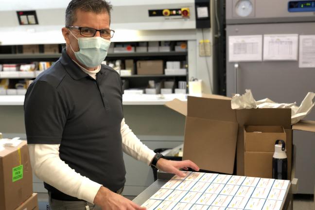 A Materials Management team member prepares to distribute a shipment of vaccinations.