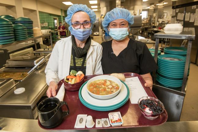 Nutrition and Food Services staff display a patient meal on a tray in the WGH kitchen.