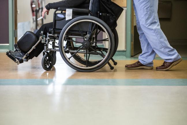 A patient is pushed in their wheelchair in Whitehorse General Hospital.